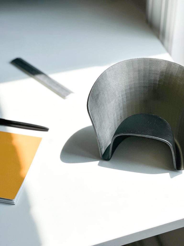 3D model of Nest chair form showing its open storage channel and simple geometry