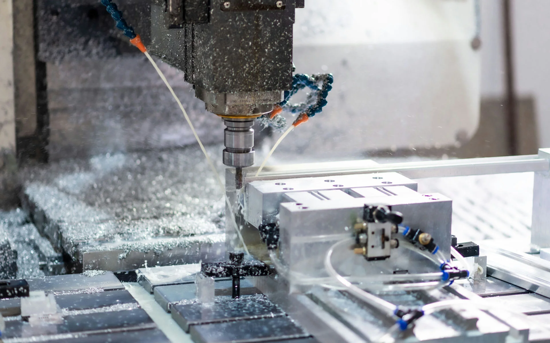 CNC machine cutting aluminum under coolant spray during precision manufacturing.