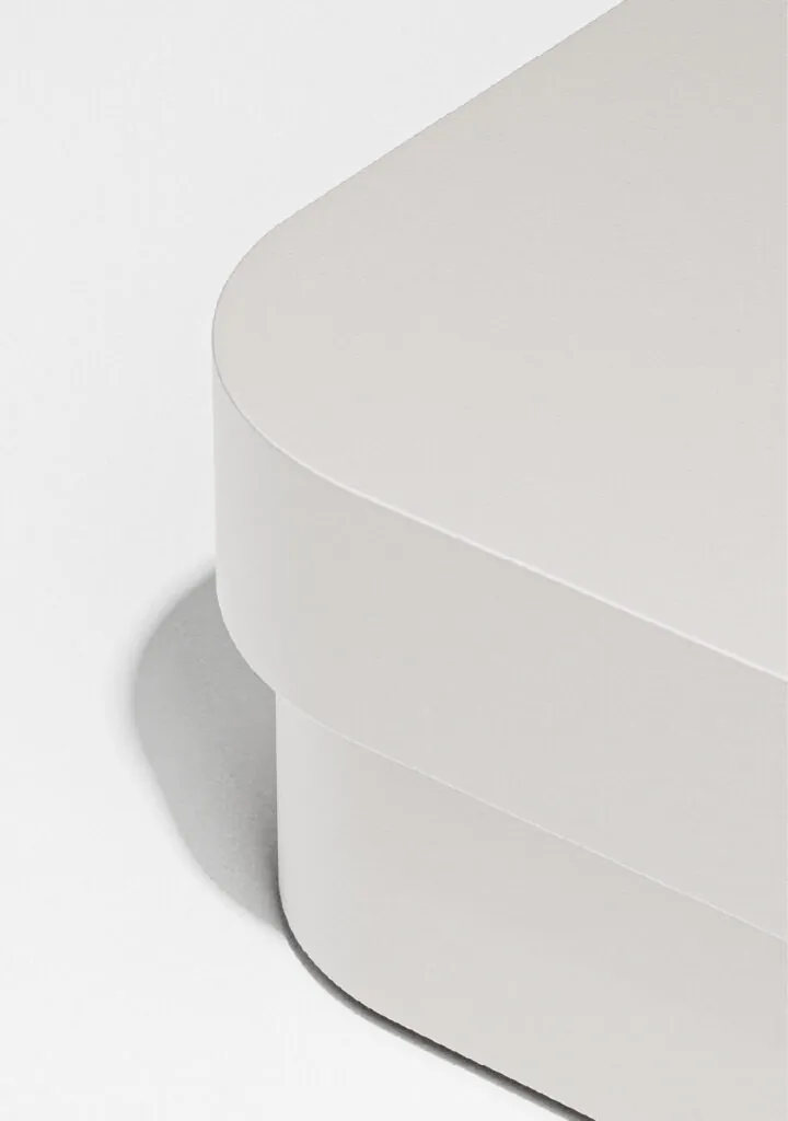 Close-up of a soft-edged grey box casting a gentle shadow on a white surface. Mango storage system by All Design Lab.