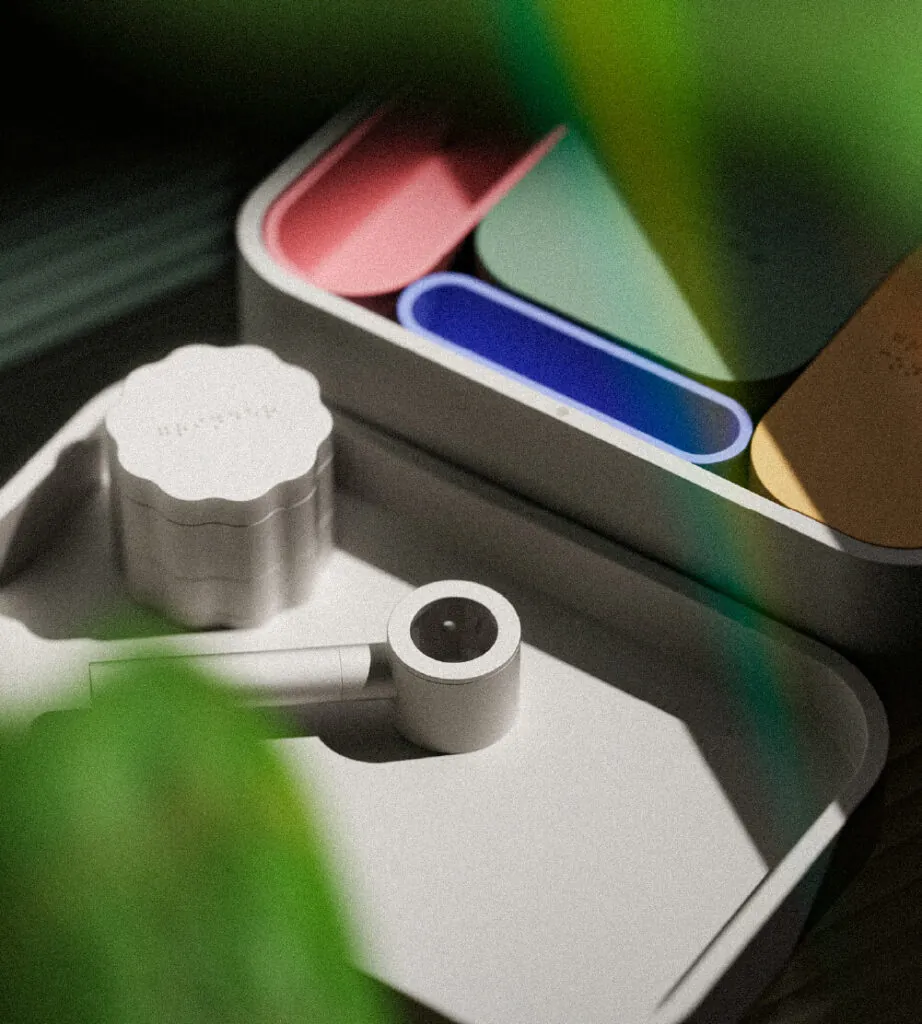 A pipe and accessories on a tray, with dynamic shadows from plant leaves. Mango Storage System by All Design Lab.