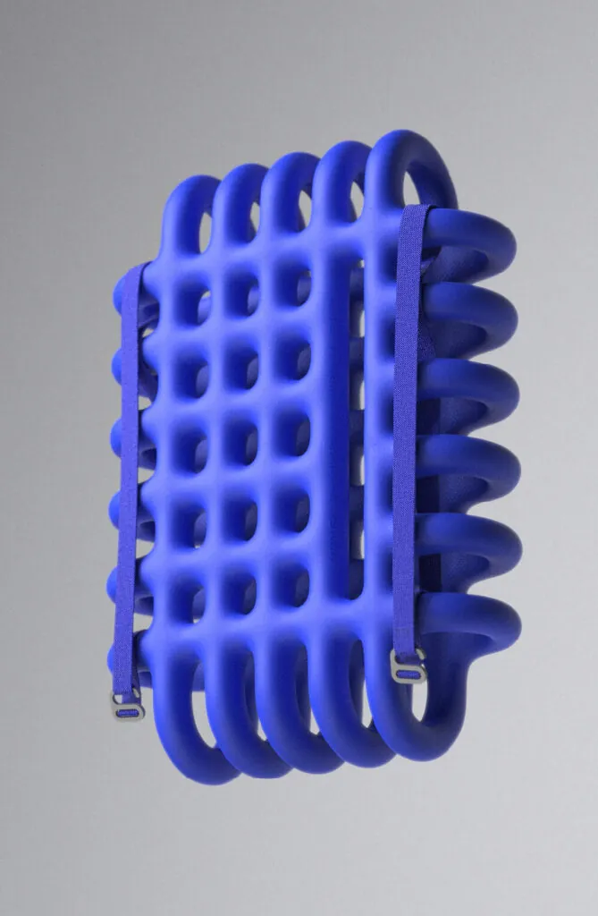 Blue cage like foam object with fabric straps. Mega Mesh Backpack by All Design Lab.