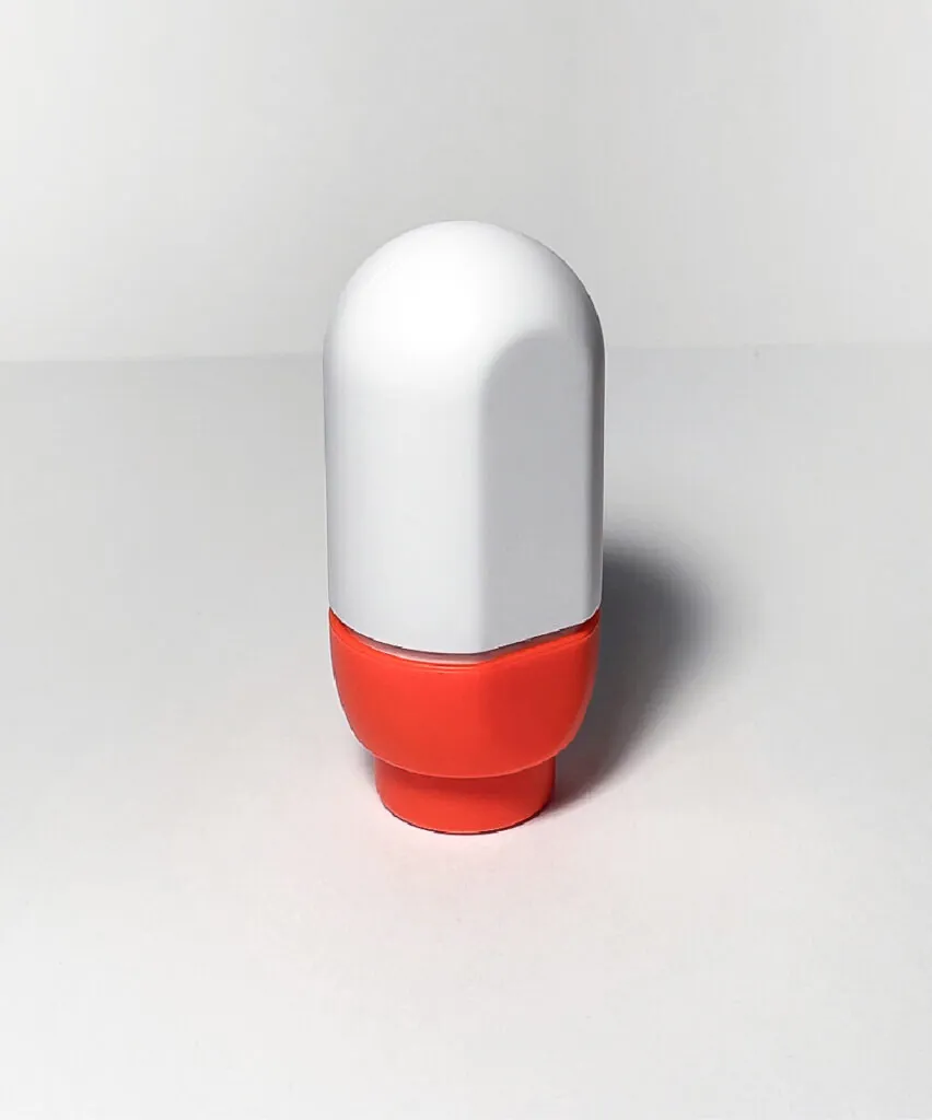 A soft, round spray bottle with a flat back standing on its top. NOK Pop refillable spray bottle by All Design Lab.