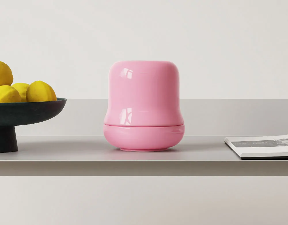 Pink ceramic matcha kit placed on a minimalist shelf next to lemons and a magazine.