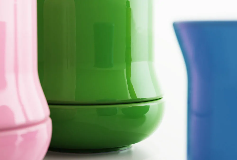 Close-up of glossy green ceramic matcha kit beside pink and blue versions.